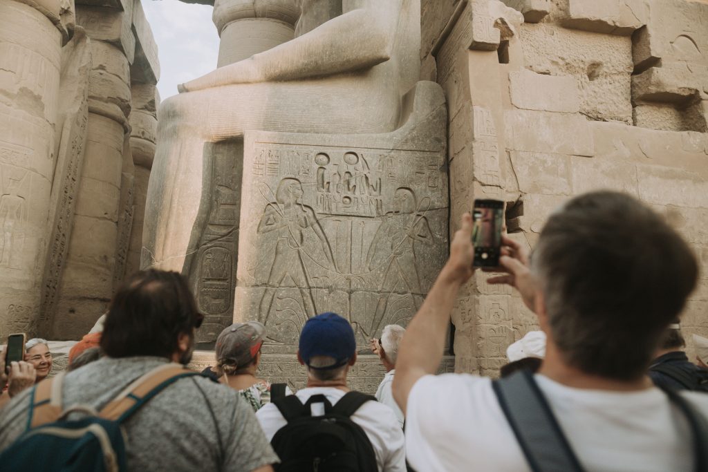Fotografierende Touristen vor einer Wandmalerei im Luxor Tempel