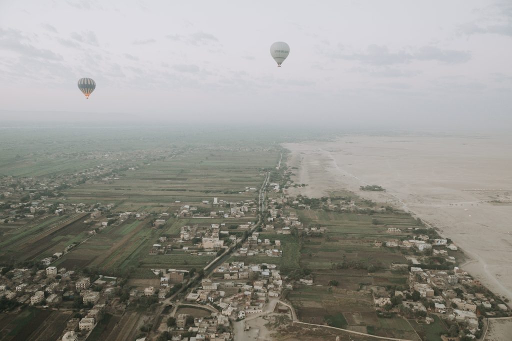 Ägypten: Blick auf die Umgebung von Luxor zwischen grünem Nilstreifen und Wüste aus einem Ballon heraus, Ballons im Hintergrund
