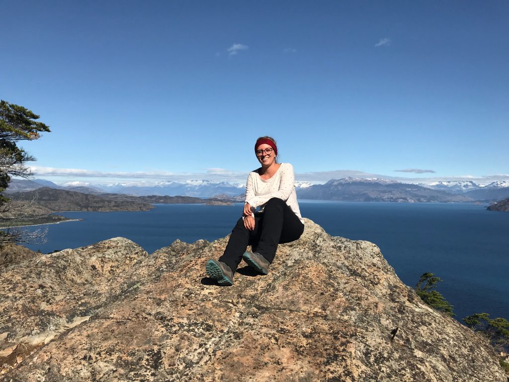 Marianne alleine auf einem Felsen sitzend am Rande eines Sees in Patagonien