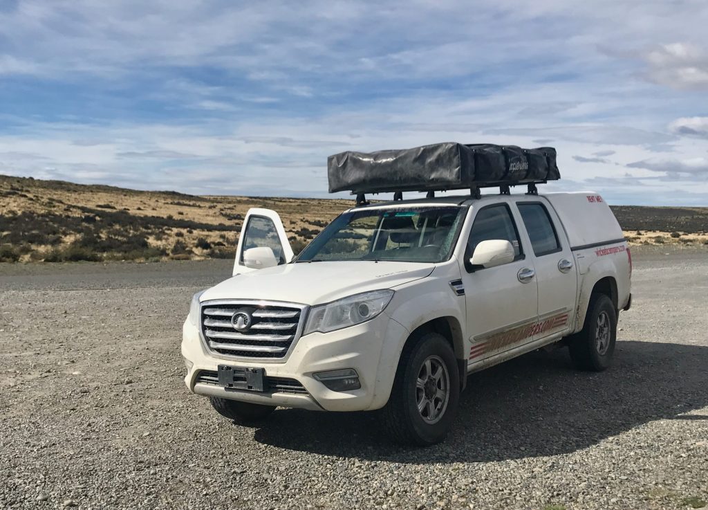 Weißer Geländewagen mit Dachzelt