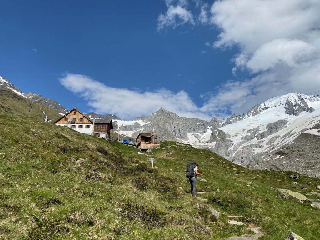 Blick hinauf aufs Furtschaglhaus in Österreich (Hüttentour auf dem Berliner Höhenweg), im Hintergrund schneebedeckte Gipfel