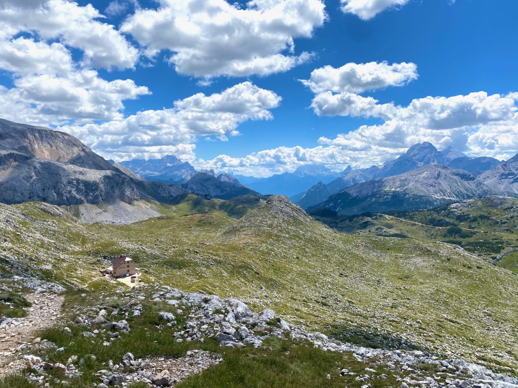Blick vom Gipfel auf die Seekofelhütte auf einer Hüttentour in den Dolomiten, umgeben von Bergen