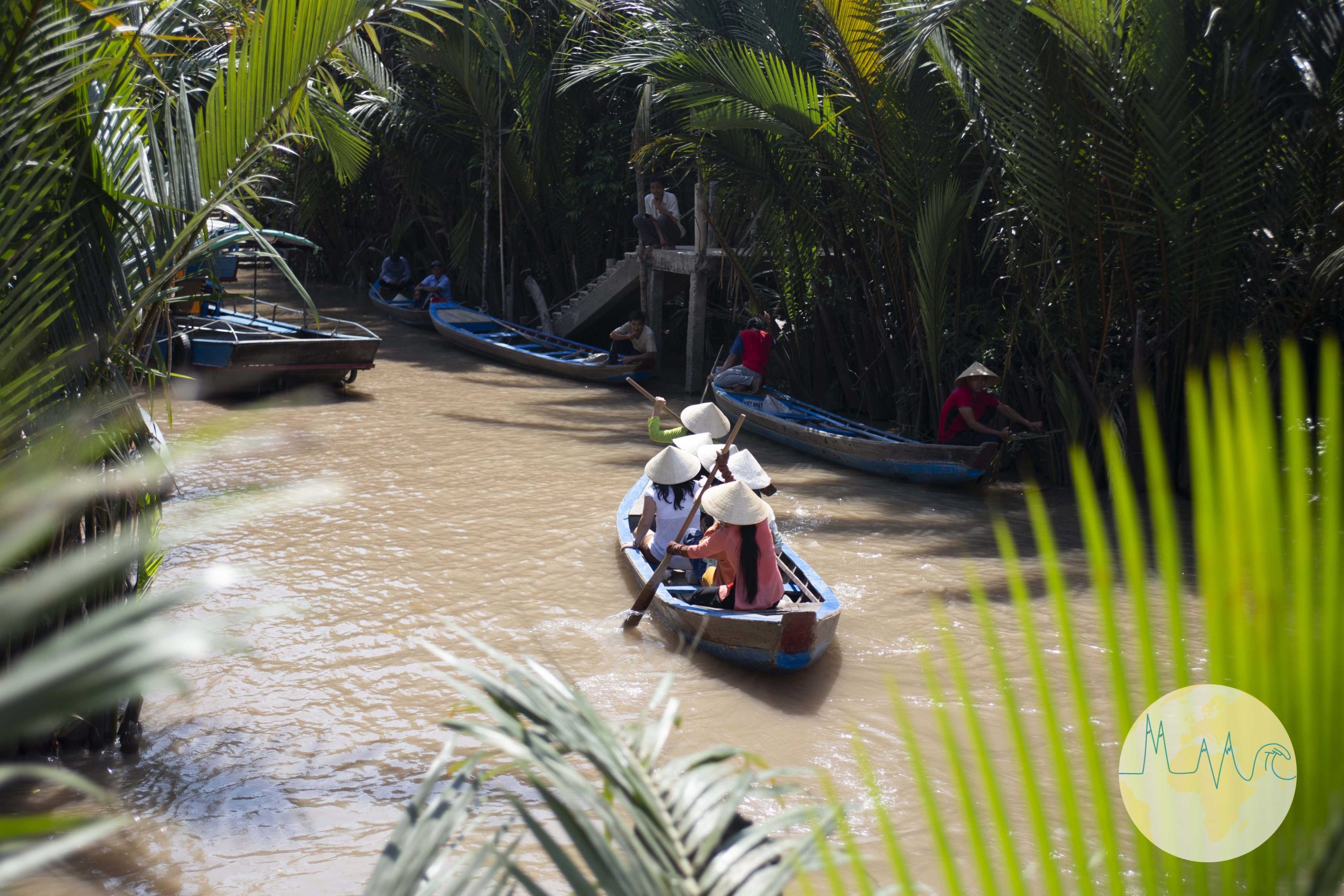Fluss mit kleinen Holzbooten zischen Farnen und Palmen in Vietnam