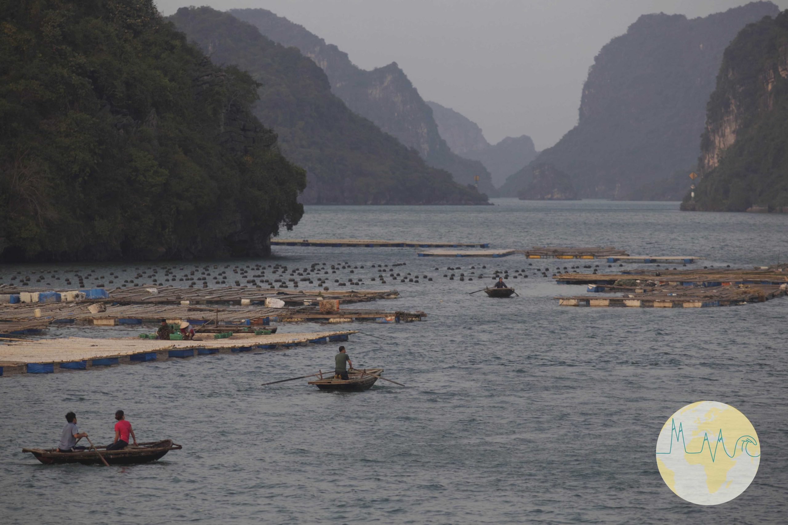 Ha Long Bay - Fischerboote in einer Bucht, Berge im Hintergrund