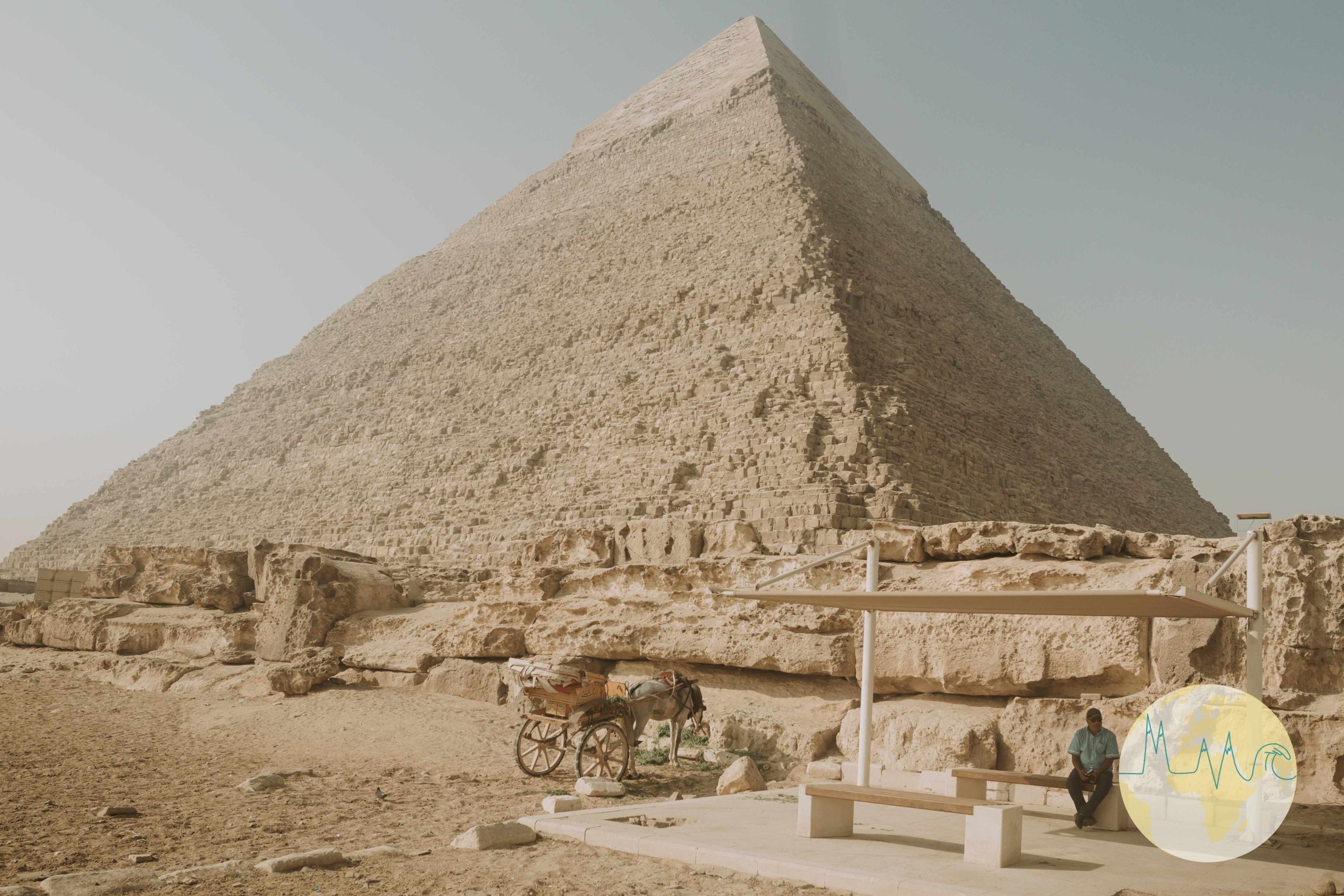 Ägypten: Haltestelle vor der Cheops Pyramide, davor ein Esel-Wagen und ein Mann auf einer Bank sitzend