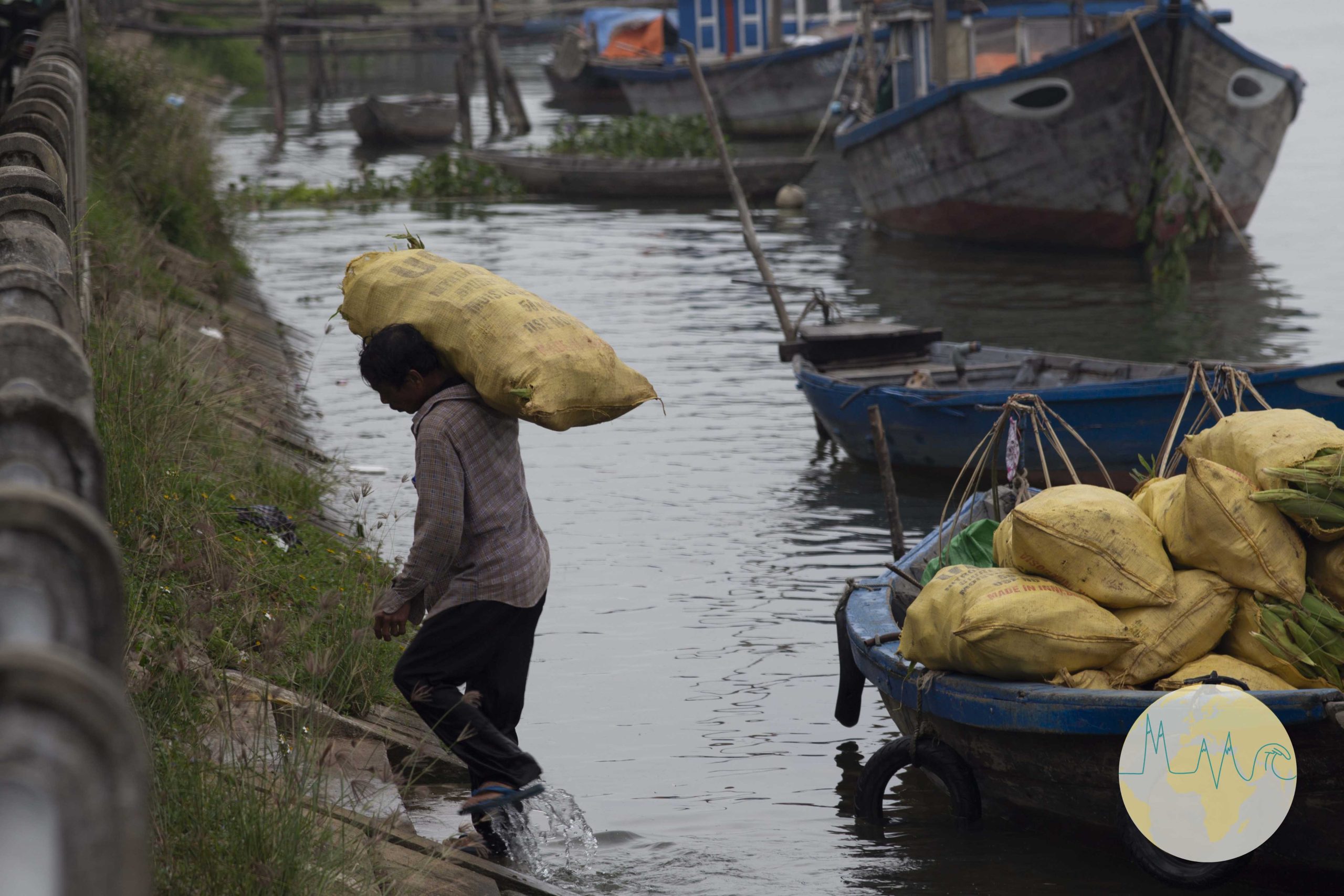 Arbeiter trägt einen Sack vom Boot an Land - Hội An - Vietnam