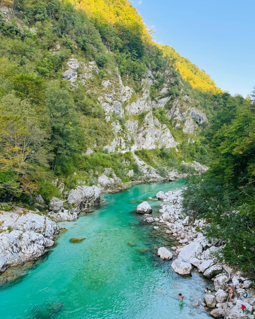 Blick auf die türkisblaue Soca in Slowenien vom Viewpoint aus, im Hintergrund Berge