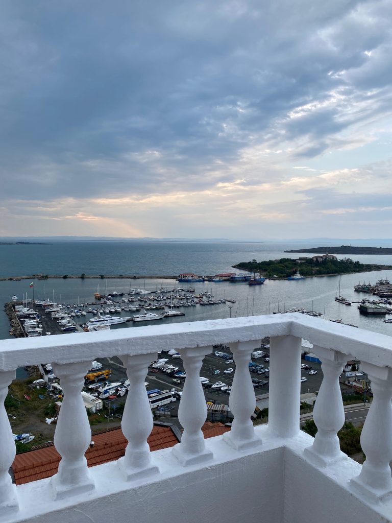 Ausblick von der Unterkunft in Sosopol - weißes Balkongeländer, dahinter Blick auf den Hafen bei bewölktem Himmel