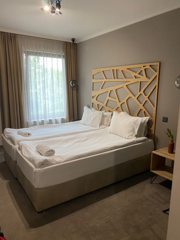 Bett vor beigefarbener Wand im Hotelzimmer in Varna