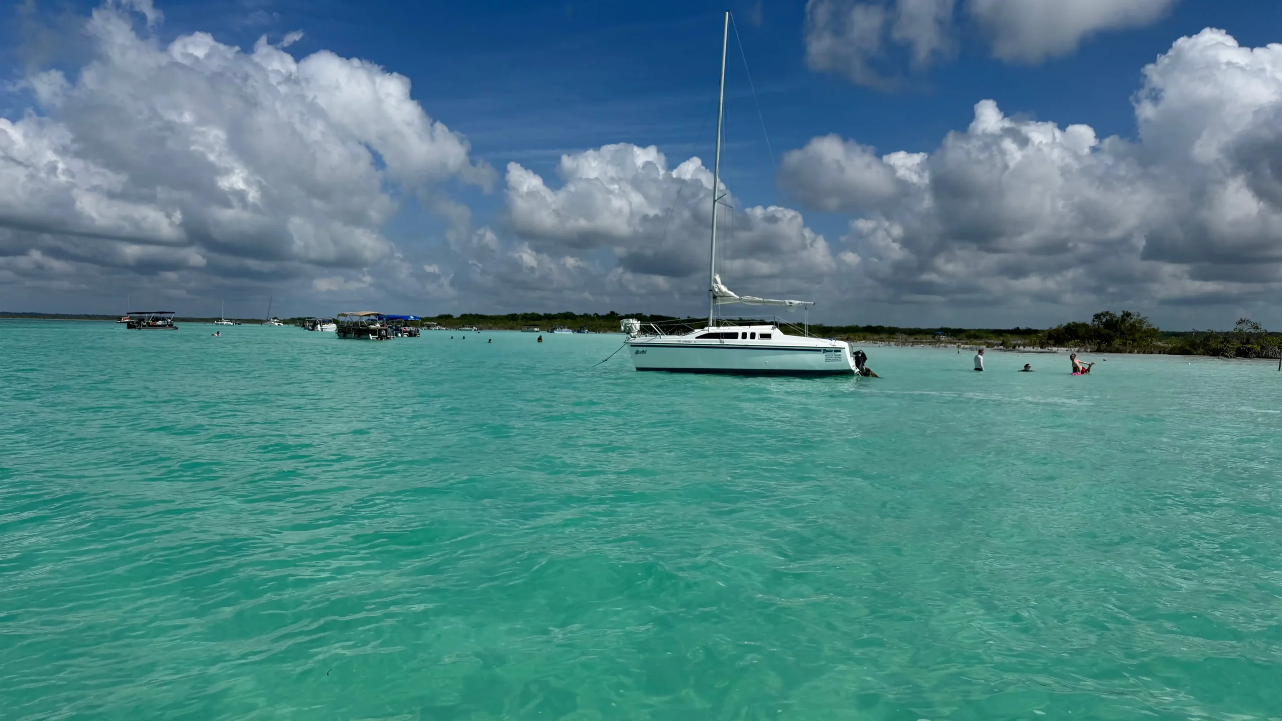 Segelschiff mit eingefahrenem Segel auf der türkisfarbenen Lagune von Bacalar