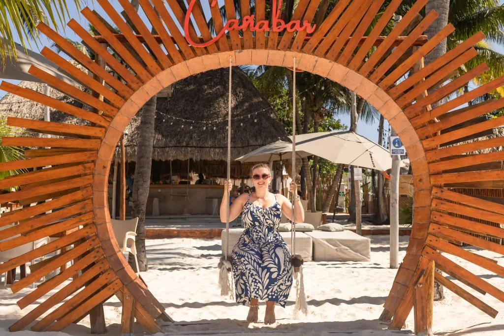 Marianne auf einer Schaukel in einem hölzernen Sonnenkreis auf der Isla Mujeres in Mexiko