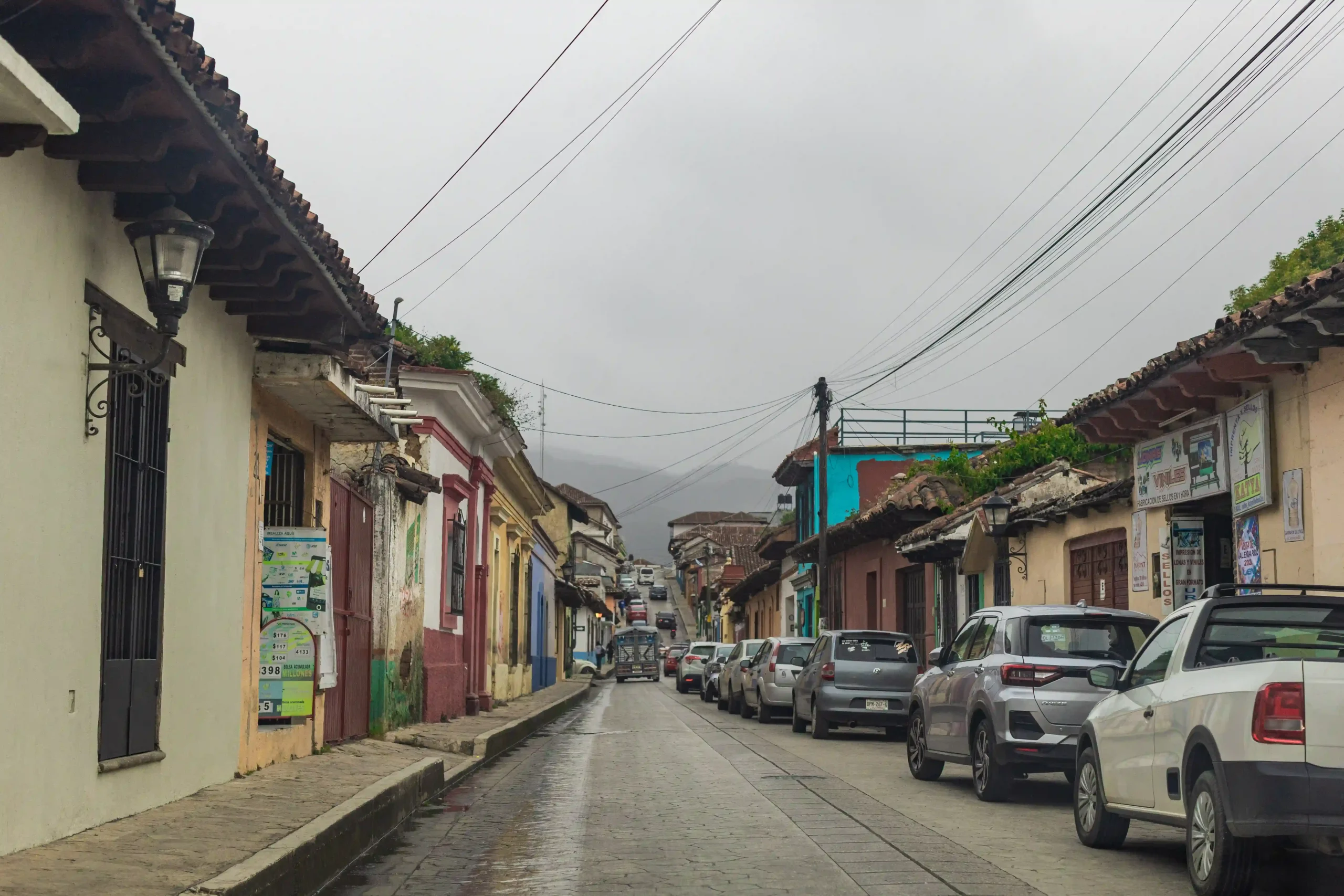 Enge Straßen von San Cristóbal de las Casa in Chiapas mit parkenden Autos und wolkenverhangenem Himmel